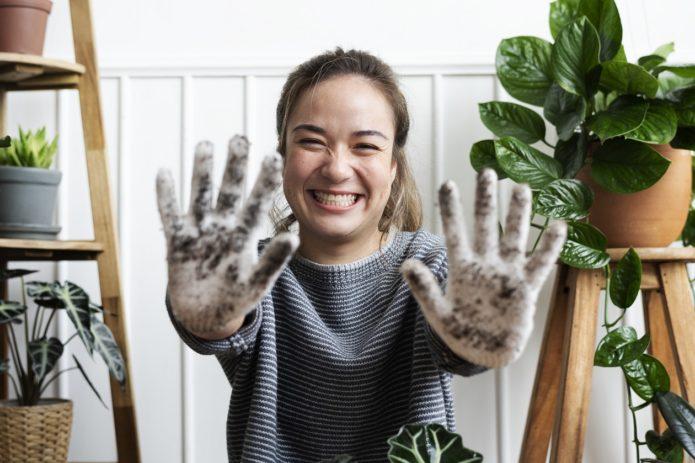 lány földes kezet mutat, környezettudatos vállakozó